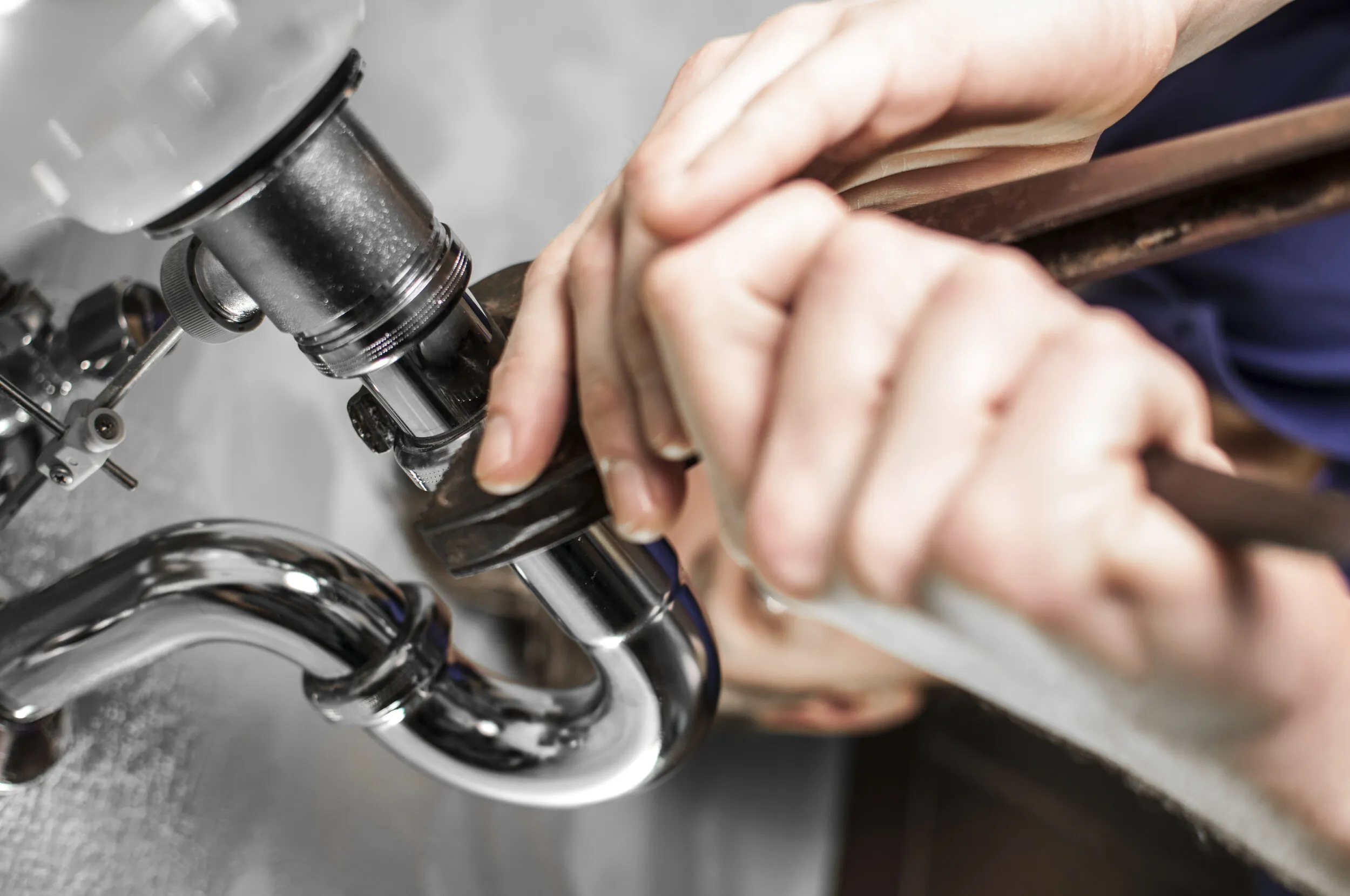 Plumber repairing a chrome sink trap