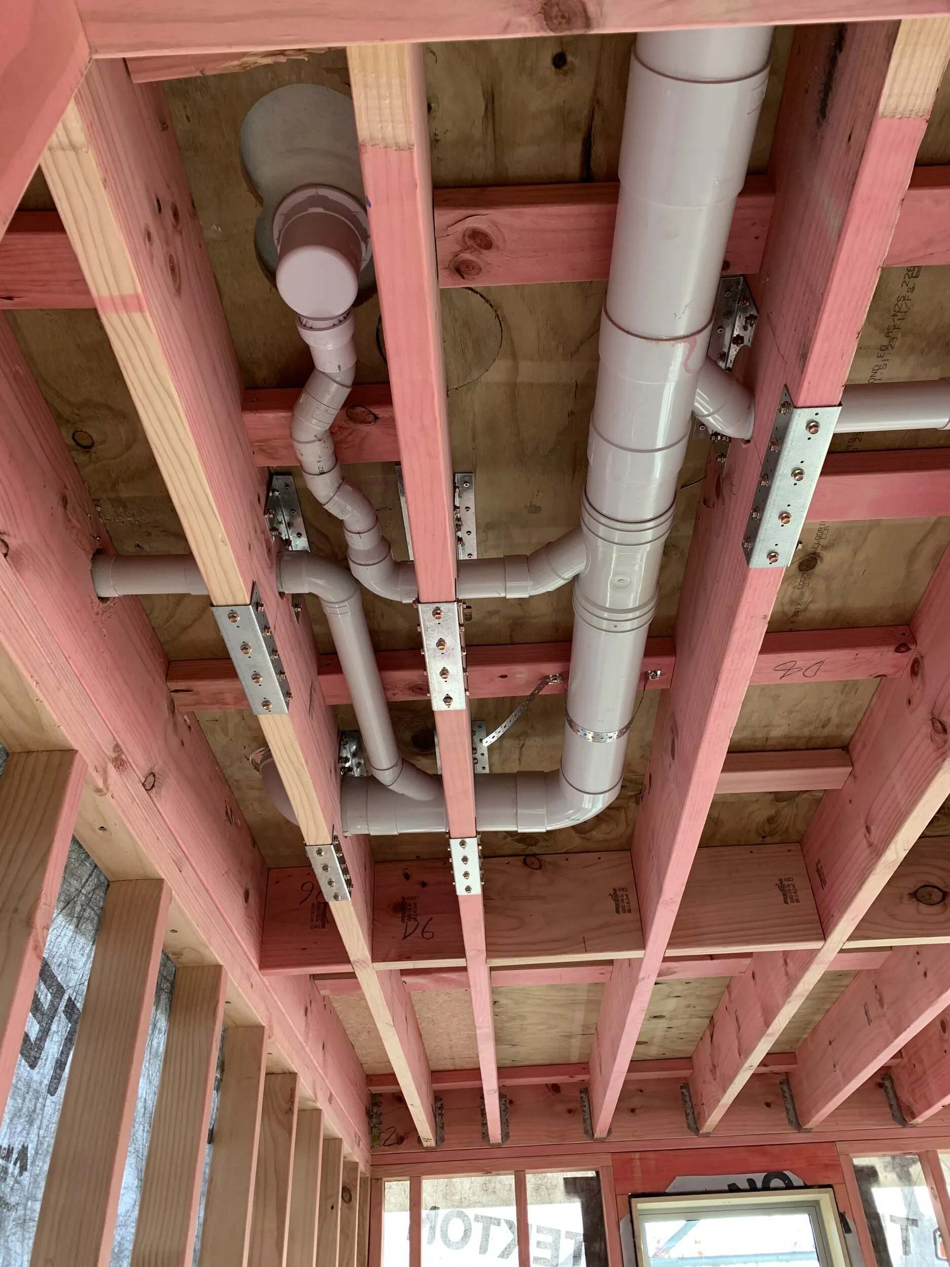 New plumbing pipework roughed into wall framing