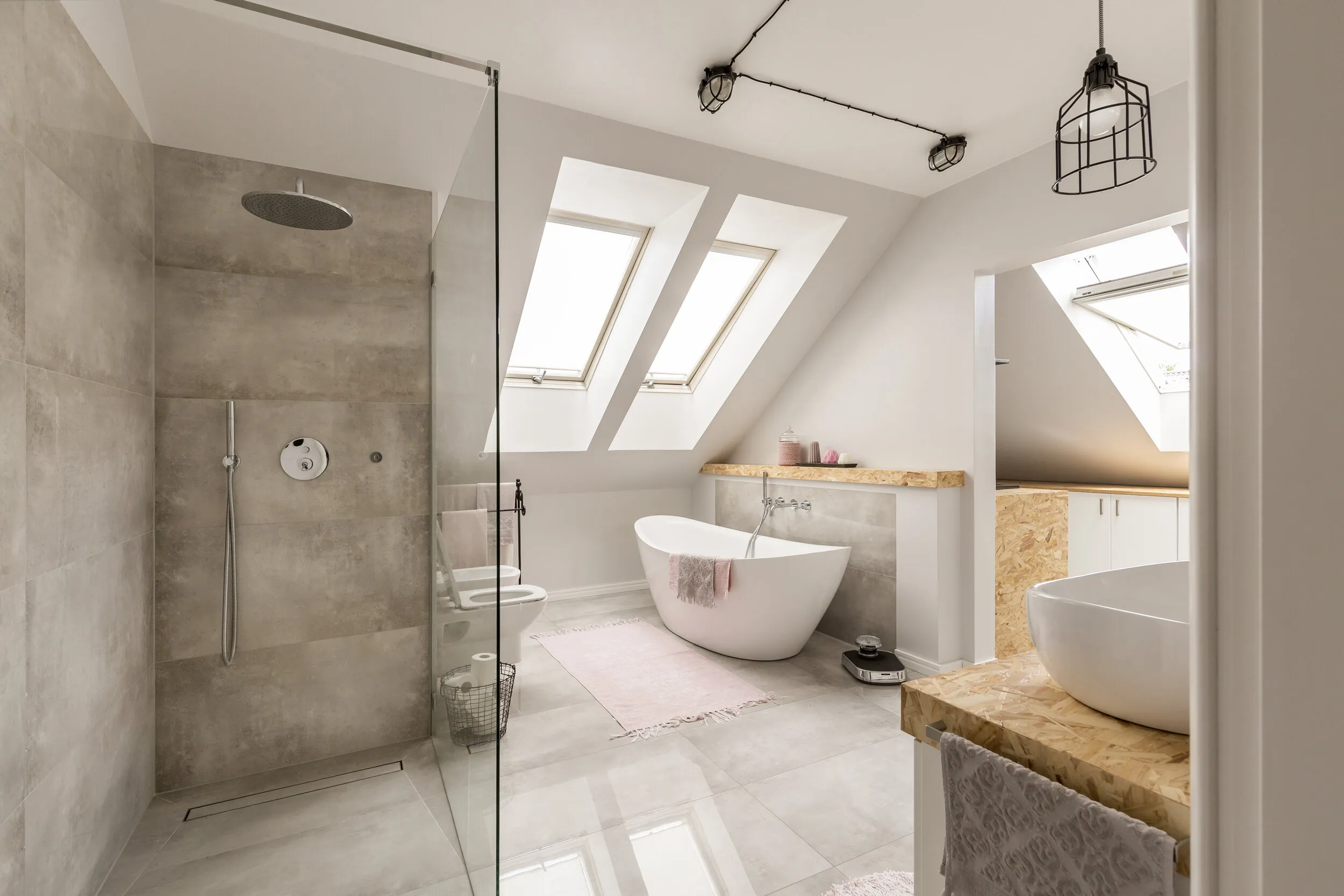 Renovated bathroom with freestanding bath by HW Group